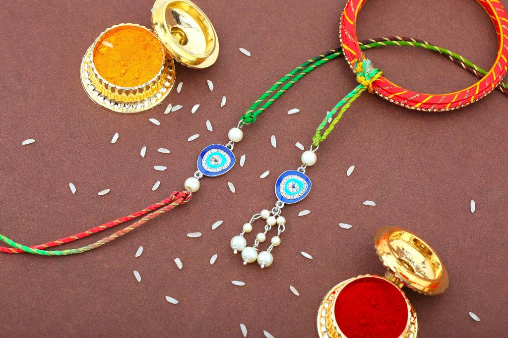  Eye Rakhi Set For Bhaiya Bhabhi With Navy Blue Enamel And White Austrian Crystals & Pearls With Fancy Silk Thread : 283-IRRAKHI