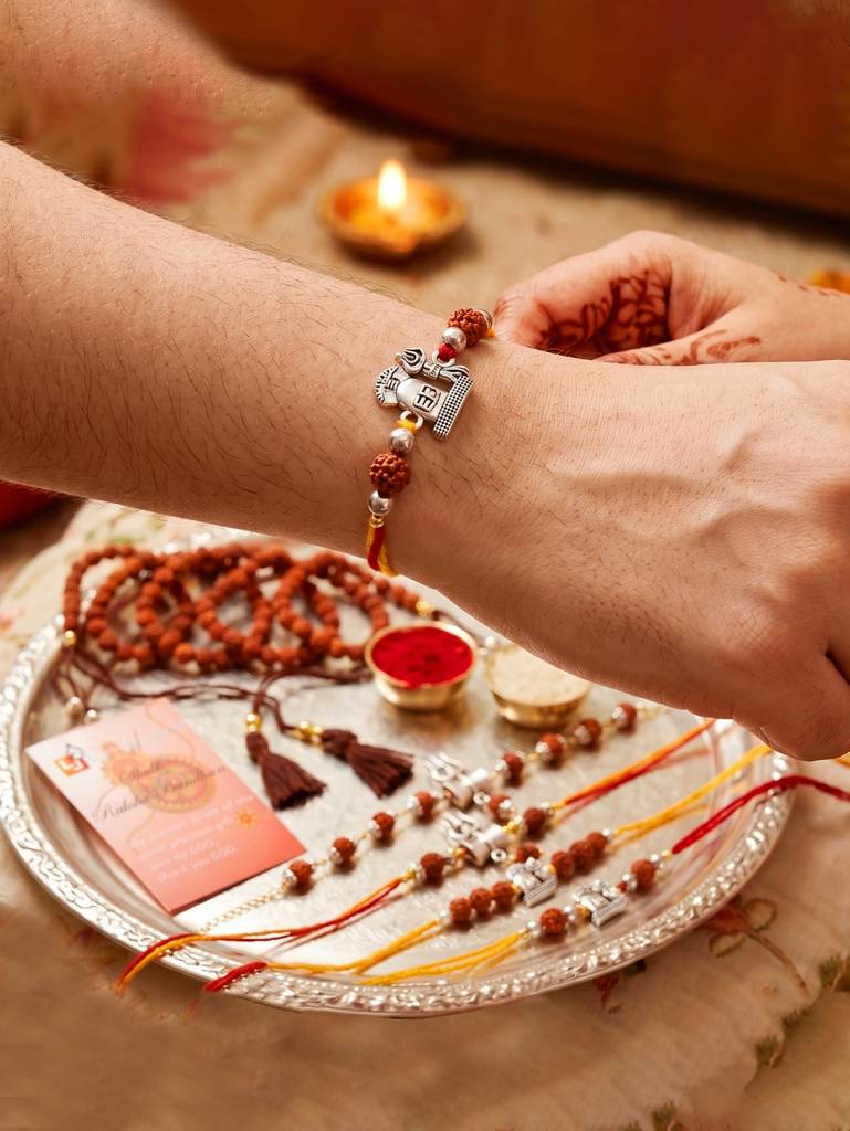 Set Of 5 Rudraksha & Silver Trishul Rakhi Set: Shiva-Themed, Metallic Accents, Roli, Chawal & Card (718 : 718-JPR1-1994-5-2026